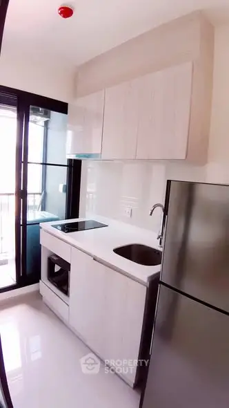 Modern kitchen with sleek cabinetry and stainless steel appliances in a bright apartment.