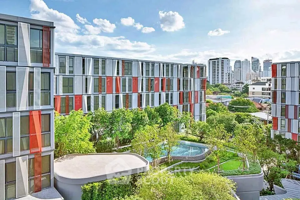 Modern apartment complex with lush greenery and city skyline view