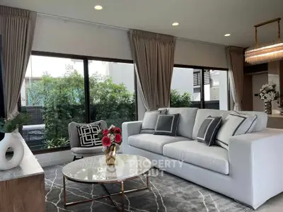 Elegant living room with modern decor and large windows overlooking greenery.