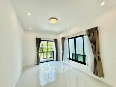 Bright living room with large windows and balcony access in modern apartment