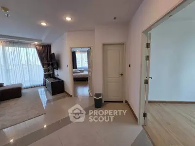 Spacious modern apartment interior with open living room and bedroom view, featuring elegant flooring and natural light.