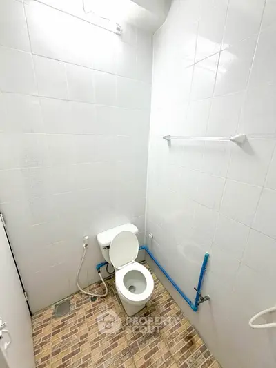 Compact bathroom with white tiles and modern fixtures