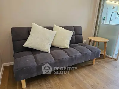 Cozy living room with modern gray sofa and wooden side table on elegant wooden flooring.