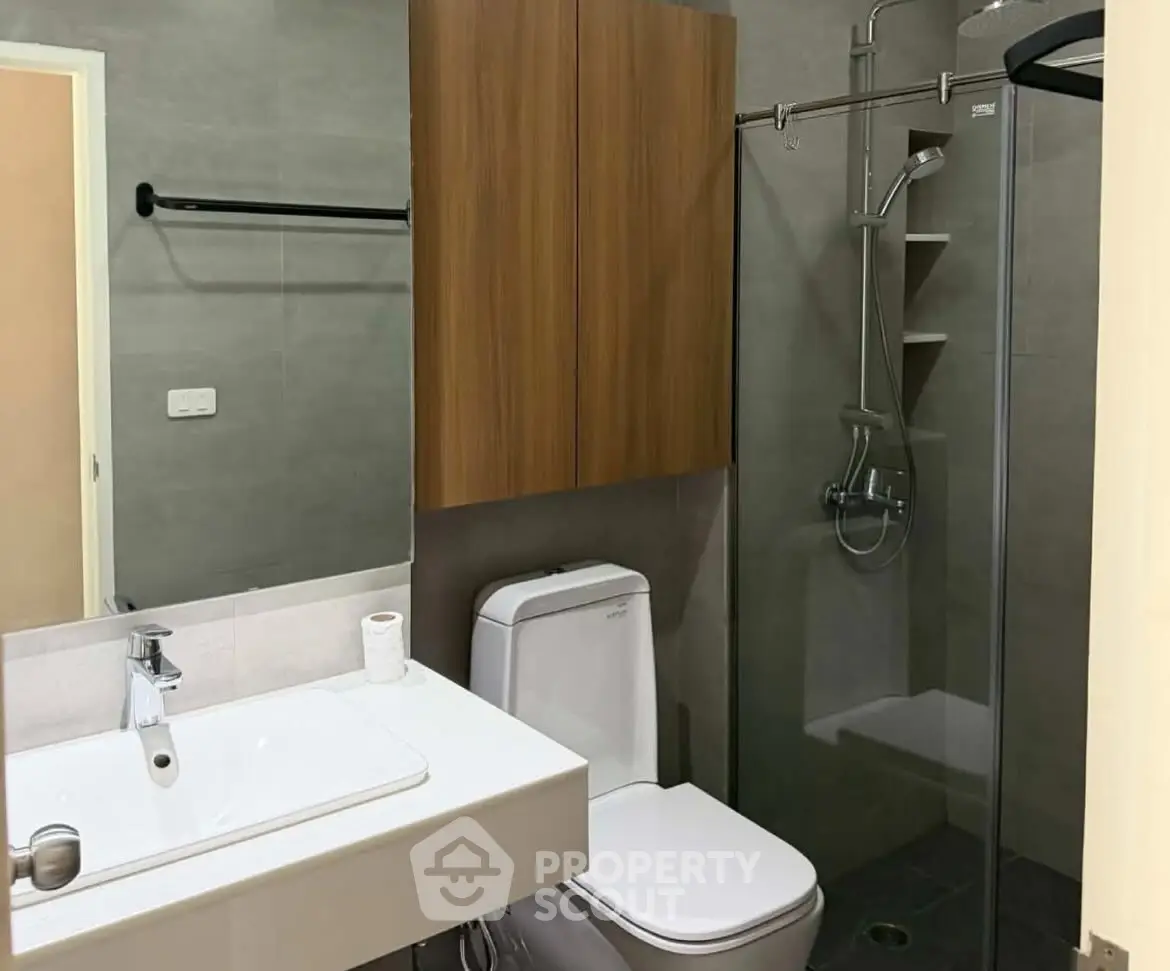 Modern bathroom with glass shower and wooden cabinetry