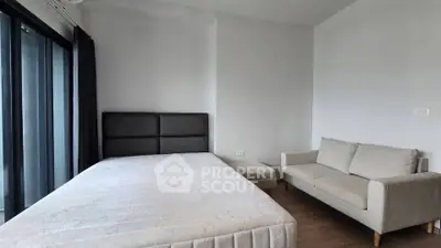 Spacious bedroom with modern decor and large windows for natural light.