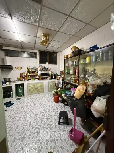 Spacious kitchen with tiled floor and ample storage, featuring a closed layout and traditional decor.