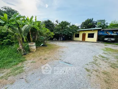 Charming rural property with lush greenery and spacious driveway, perfect for serene living.