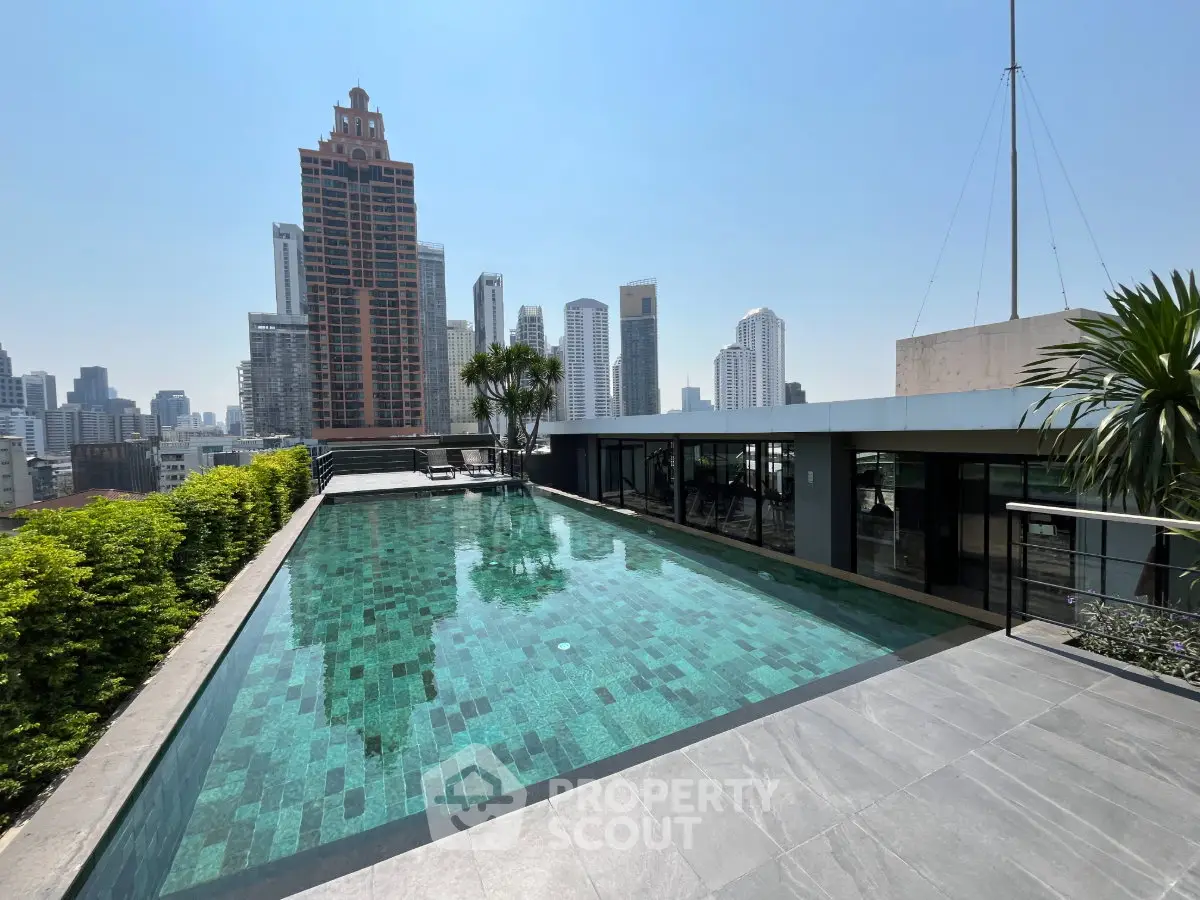 Luxurious rooftop pool with stunning city skyline views in modern high-rise building.