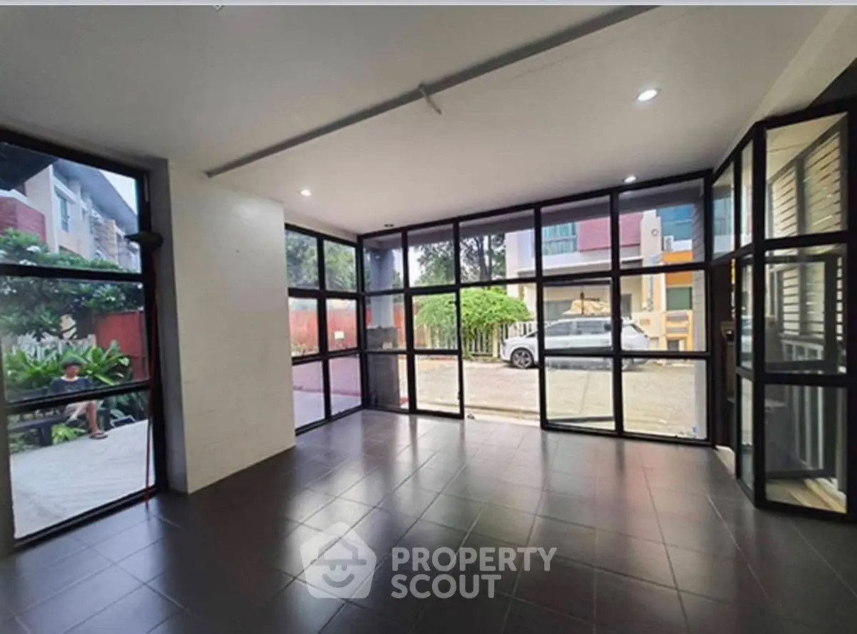 Spacious modern room with large windows and sleek tile flooring, perfect for versatile use.