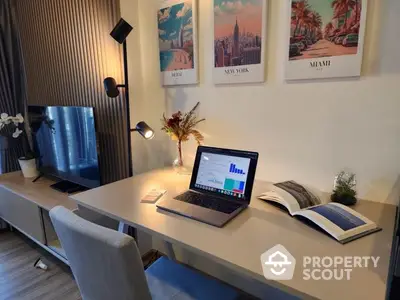 Modern study area with sleek desk, laptop, and stylish decor in a contemporary apartment.