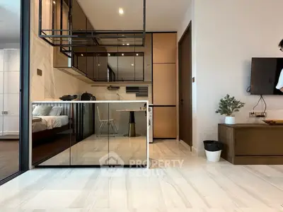 Modern open-plan living space with sleek kitchen and cozy bedroom view.
