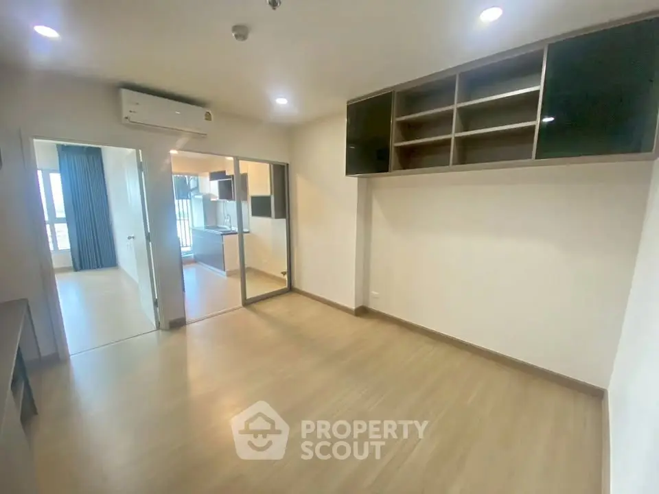 Spacious modern living room with wooden flooring and built-in storage, ideal for urban living.