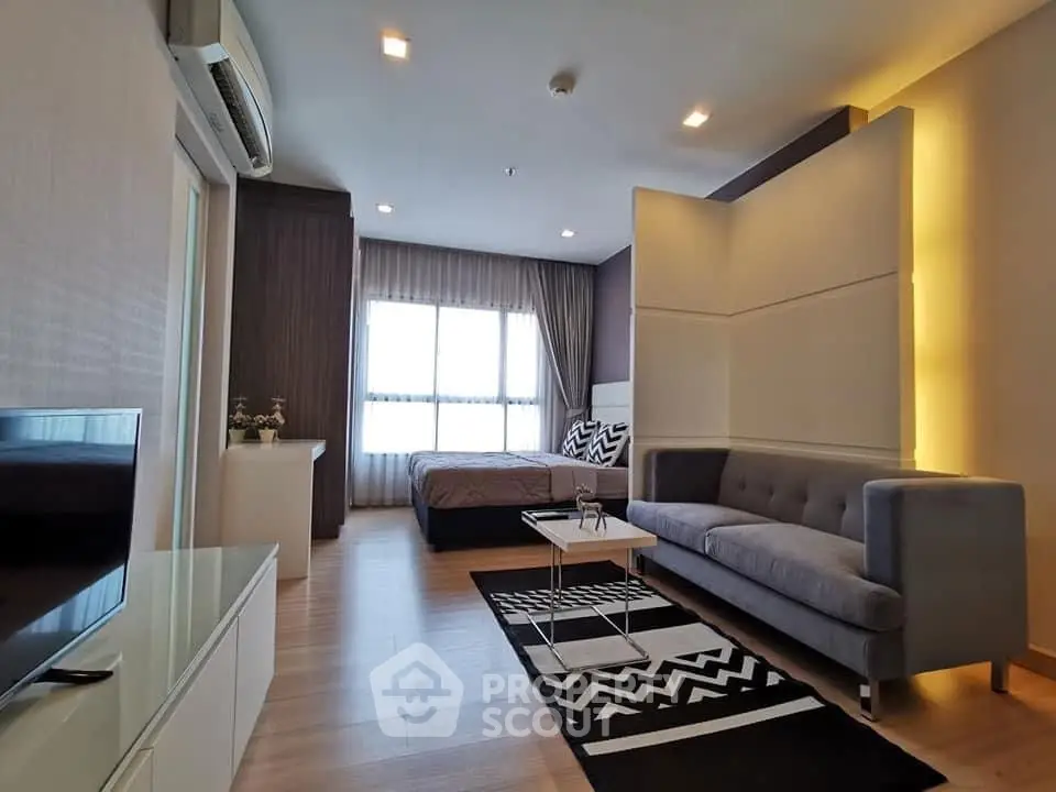 Modern studio apartment with stylish decor, featuring a cozy living area and a comfortable bed.