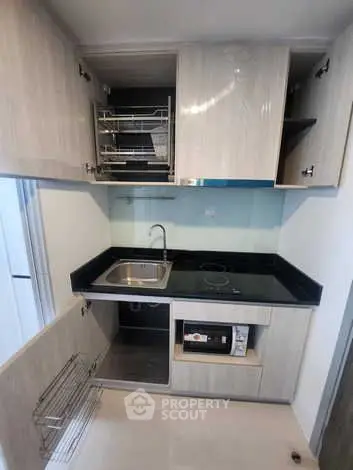 Modern compact kitchen with sleek cabinetry and built-in appliances