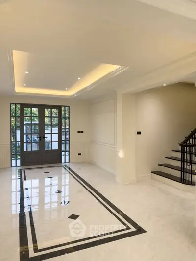 Elegant living room with marble flooring and modern staircase in luxury home