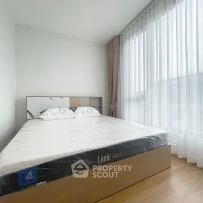 Spacious bedroom with large window and modern bed in a bright apartment.