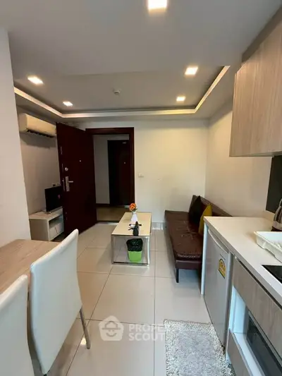 Modern living room with sleek furniture and open kitchen layout in a stylish apartment.