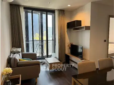 Modern living room with balcony view, stylish furniture, and natural light in a contemporary apartment.