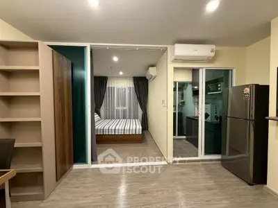 Modern open-plan apartment with sleek kitchen and cozy bedroom, featuring stylish decor and ample natural light.