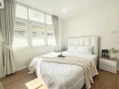 Bright and cozy bedroom with large window and elegant decor.