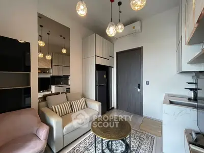 Modern living room with cozy seating and stylish lighting in a compact apartment.