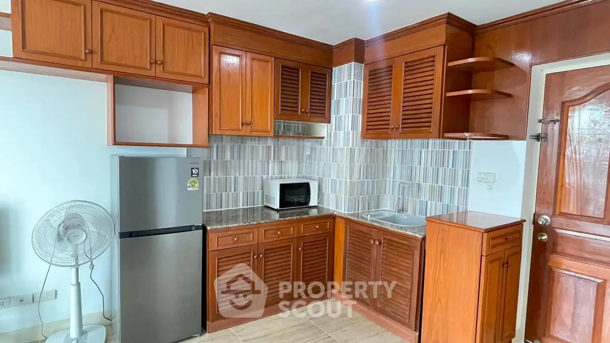Charming kitchen with wooden cabinets and modern appliances in cozy apartment
