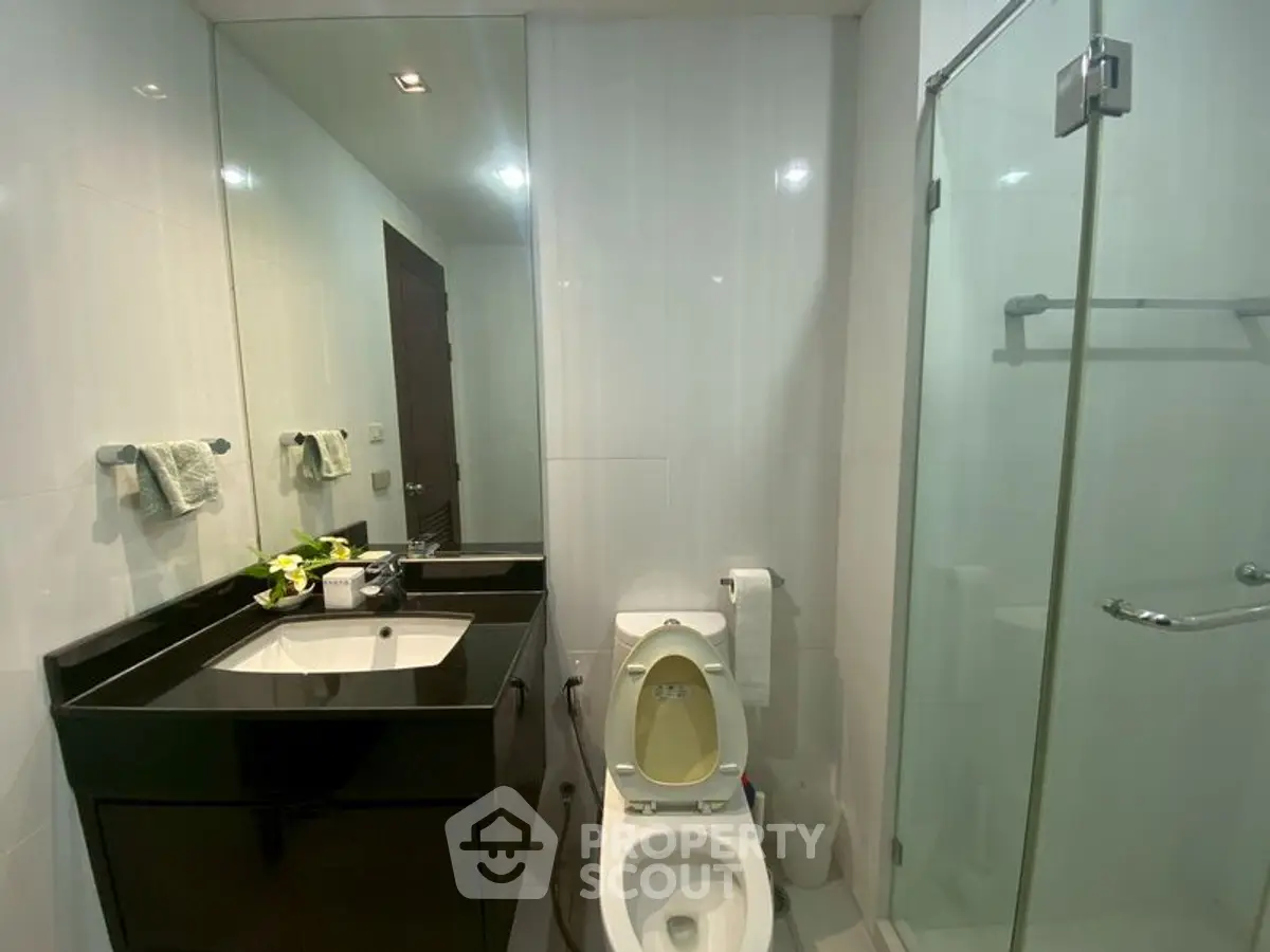 Modern bathroom with glass shower and sleek black vanity