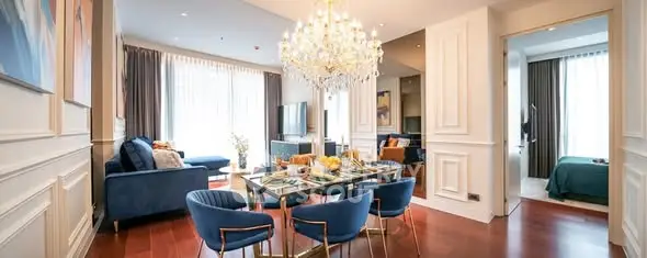 Luxurious open-plan living and dining area with elegant chandelier and modern decor.