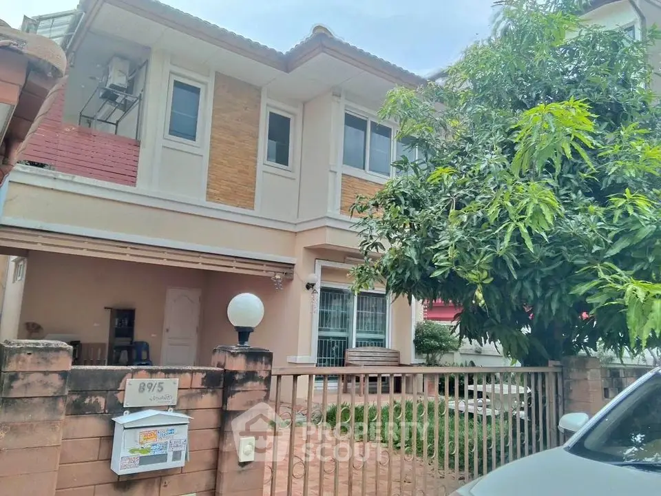 Charming two-story house with lush greenery and spacious front yard