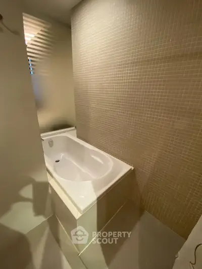 Modern bathroom with elegant bathtub and stylish tile wall design.