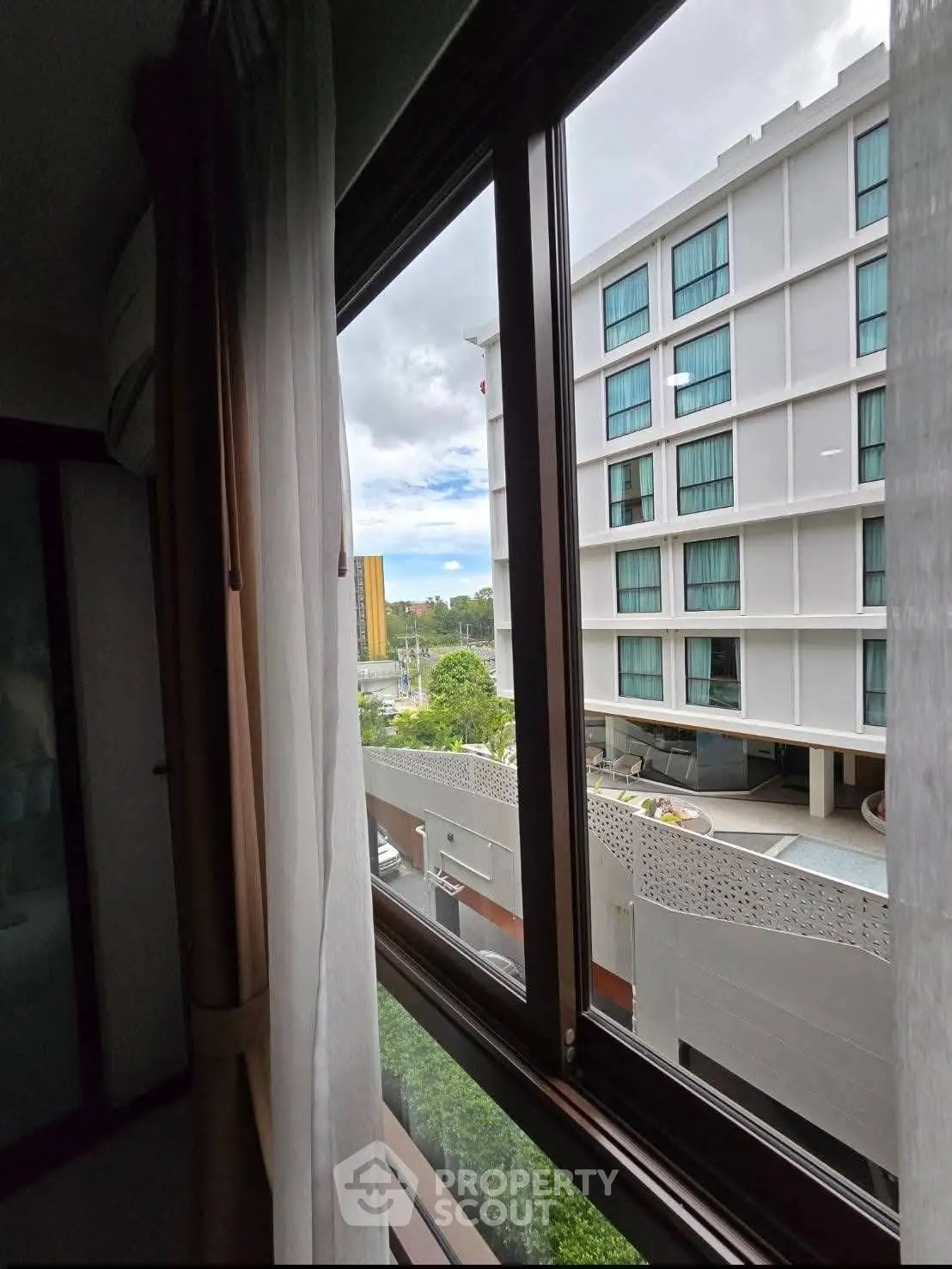 Modern apartment view from window showcasing nearby building and urban landscape.
