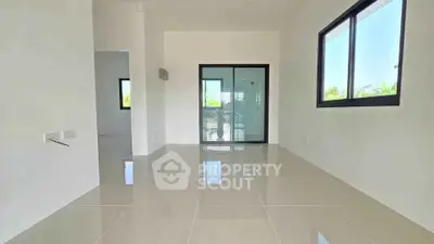 Spacious modern living room with large windows and glossy tiled floors