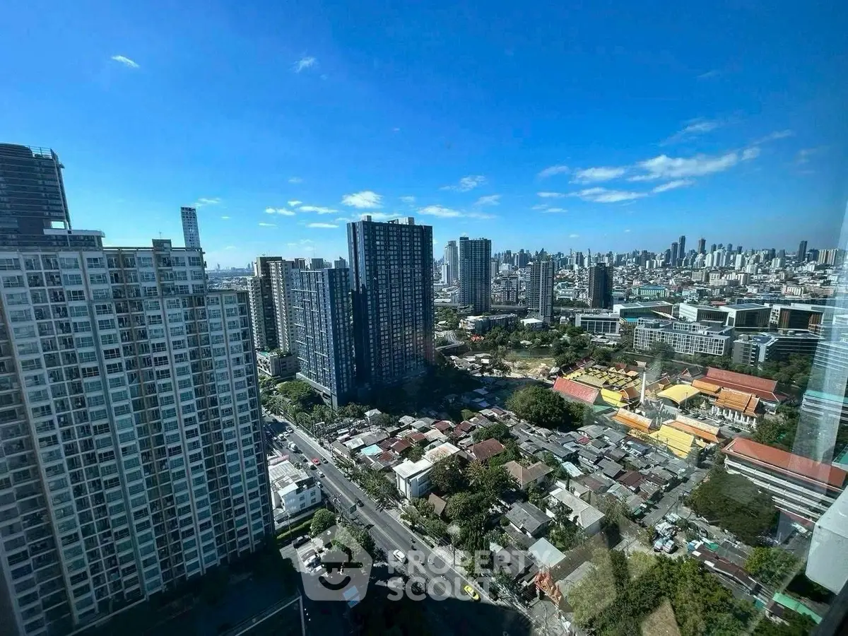 Stunning cityscape view from high-rise apartment with clear blue skies.