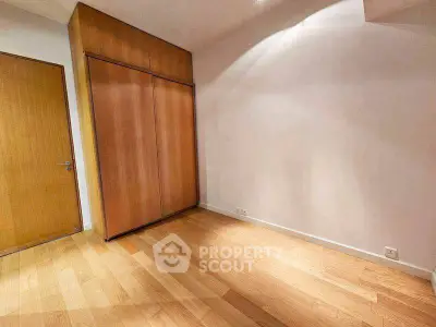 Spacious empty room with wooden flooring and built-in wardrobe, perfect for customization.