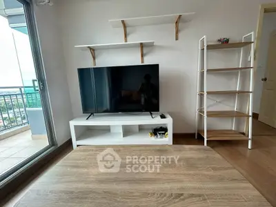 Modern living room with TV, shelves, and balcony view in stylish apartment.
