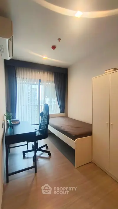 Modern bedroom with study desk and large window offering city view