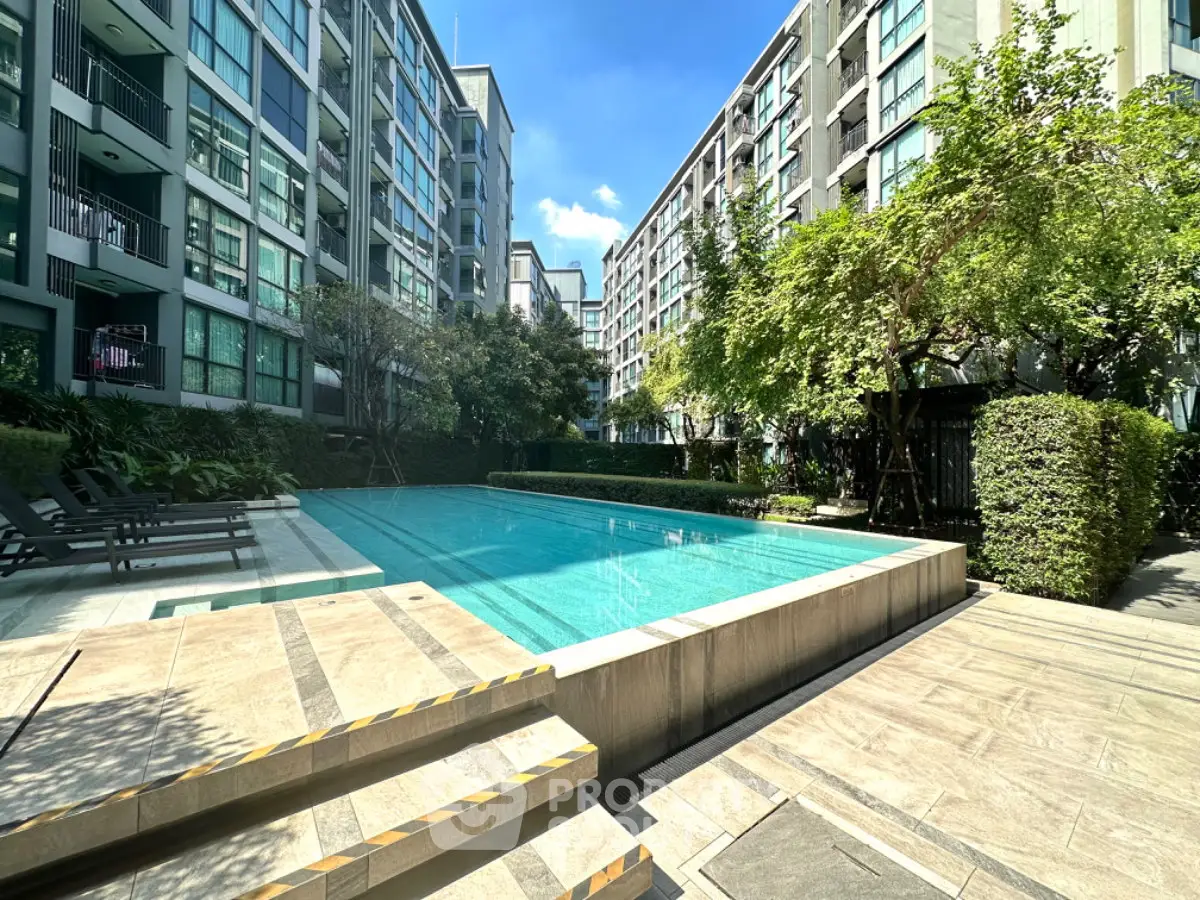 Luxurious condominium with a stunning outdoor pool and lush greenery, perfect for relaxation and leisure.