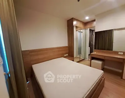 Modern bedroom with wooden furniture and ensuite bathroom in a cozy apartment.