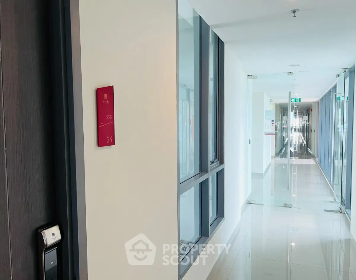 Modern apartment corridor with sleek design and glass doors, showcasing a contemporary living environment.