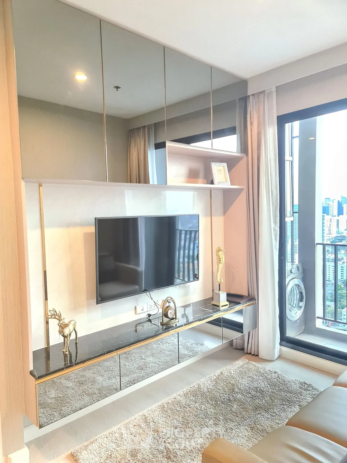 Luxurious living room with modern decor and stunning city view from large window.