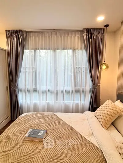 Cozy bedroom with elegant curtains and soft lighting, featuring a plush bed and stylish decor.