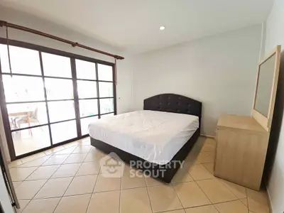 Spacious bedroom with large windows and modern furnishings