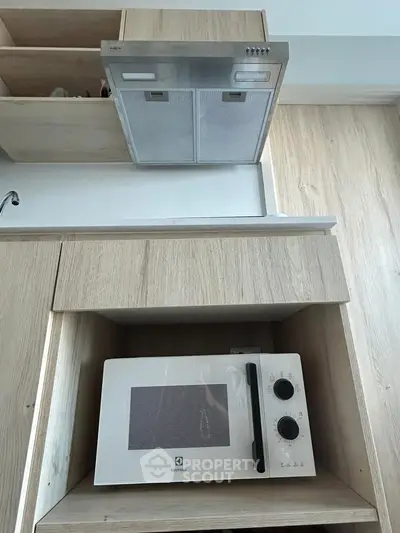 Modern kitchen with built-in microwave and sleek wooden cabinetry