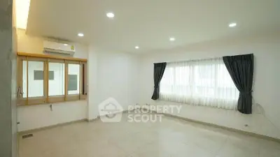 Spacious unfurnished living room with large windows and modern lighting