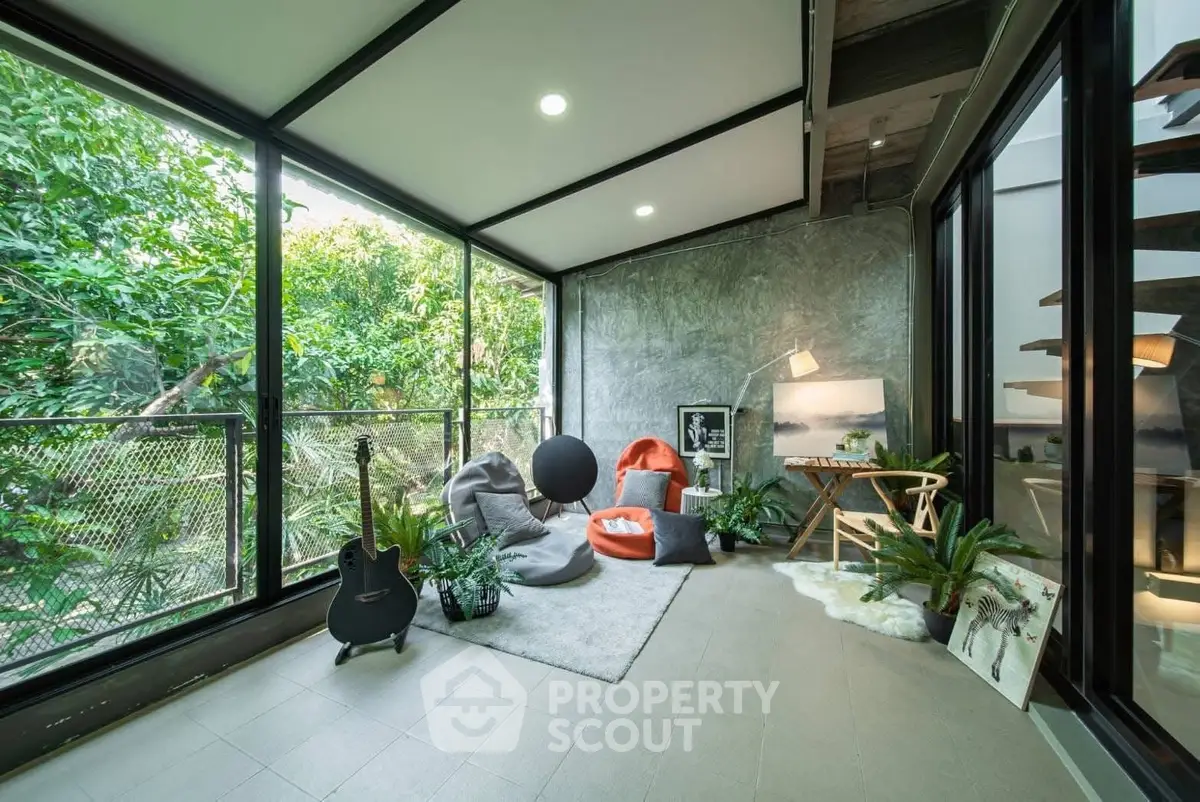 Stylish modern living room with large windows and lush greenery view