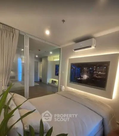 Modern bedroom with stylish decor and ambient lighting, featuring a cozy bed and sleek air conditioning unit.