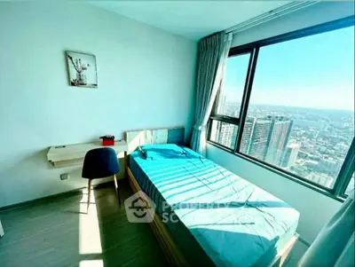 Bright bedroom with city view, featuring a single bed and study desk.