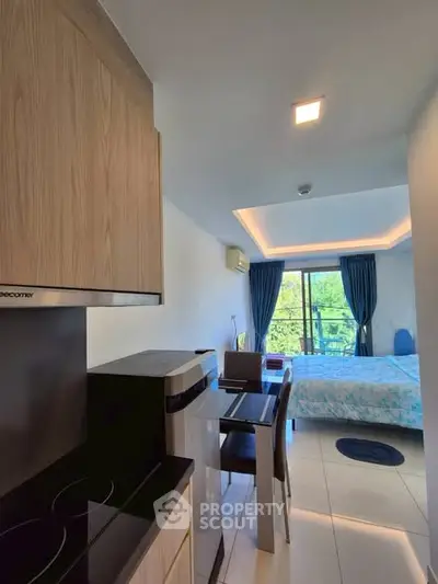 Modern studio apartment with open kitchen and scenic balcony view