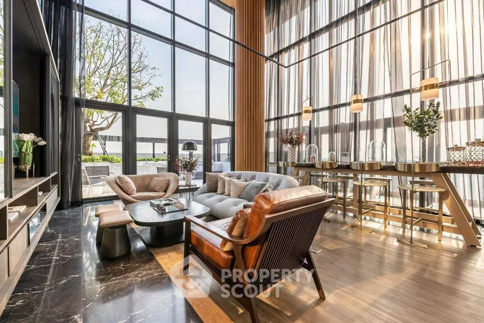Luxurious living room with high ceilings and large windows offering stunning views.