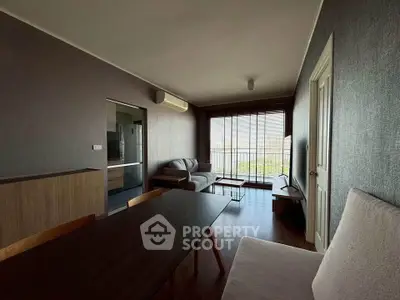 Modern living room with stylish furniture and large windows offering natural light and a serene view.